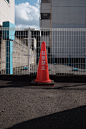 red traffic cone on gray asphalt road during daytime