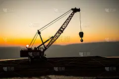 工业背景与建筑起重机的剪影在惊人的日落天空。傍晚天空下的塔吊。工业的天际线。有选择性的重点