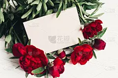 鲜花贺卡概念，春季时尚形象。模拟。美丽的红色牡丹花束与牛皮纸在白色木制乡村背景。空间的文本。婚礼的邀