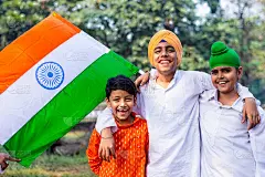 三个不同宗教信仰的可爱的印度小孩在公园附近挥舞着三色旗，背景是绿色植物。