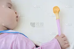 穿着玫瑰夹克的可爱宝宝在喂奶的时候睡着了