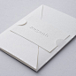 Cotton Wove business card with heavy blind emboss logo sat in a folded receipt holder for Roganic restaurant