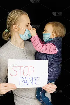 父亲(男人)和女儿(孩子)戴着医用口罩，佩戴着防恐慌海报，黑色背景。冠状病毒流行期间的家族