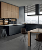 Twelve kitchen with base units in black frosted glass and anodized aluminium, worktop with double thickness 12 and 52 mm in DuPont Corian pearl gray. Tall units and wall units in elm. Modular equipments Shaker in black embossed lacquered aluminium with ba