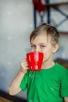 早上好。一个小男孩在餐桌旁喝茶，抱着一只泰迪驼鹿。一个充满奇迹和满足欲望的时代。