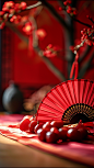 桌子上放着一把红色的折扇，旁边放着几颗红梅，背景比较模糊，好像在举行婚礼。中国的新年海报创造了一个独特的场景。春节气氛，喜庆，特写，高端，静物拍摄--ar 34-v 6 (49)