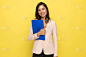 confident young businesswoman holding blue clipboa