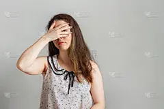 情绪和人。一个穿着衬衫的黑发姑娘用手蒙住眼睛，透过手偷看。保密和好奇的情绪。本空间