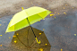 Close up on bbright yellow umbrella in a puddle Premium Photo