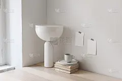 现代早餐静物画。靠近窗户的桌子上放着一杯咖啡、书籍和新潮的几何大理石台灯。空白的记事本和海报模型贴在