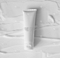 模型白色塑料管的保湿霜，乳液，洗面奶或洗发水在涂抹霜纹理背景俯视图。精致纯净的护肤产品
