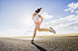 Low angle view of Caucasian woman running on remote road by Gable Denims on 500px