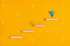 木制的台阶通向手绘的灯泡。理念、创造力、抱负或成功的概念。