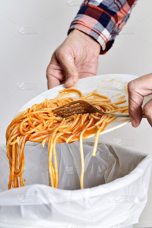 年轻人把残羹剩饭扔进垃圾桶