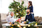 A small girl with father and grandfather sitting on a sofa at Christmas time, having fun.