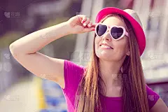 一个戴着草帽和太阳镜的女人在港口坐着游艇