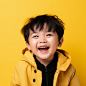 cute asian little boy with short hair is posing for a photograph
