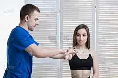 医生诊断女孩的肩膀和尺骨。按摩师检查有张力的女肘臂和�