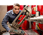 A man wearing safety goggles leans over a scientific device.