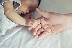 Asian mother holds her  newborn baby