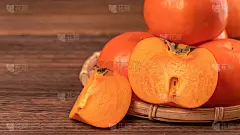 切好的甜柿子卡吉放在竹筛篮上，深色木桌以红砖墙为背景，中国农历新年水果的设计理念，拉近了距离。