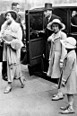 摄于1937年4月- Elizabeth英女王和George VI英王带着11岁的Elizabeth公主和Margaret公主在Central Hall。公主们穿着一样的修身翻领大衣，搭配着丝带装饰的帽子。