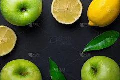 框架组成的新鲜生的绿色有机苹果，多汁的柠檬叶在黑色的背景。健康的生活方式，维生素，排毒，平衡的饮食，