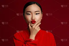吹吻。时尚肖像年轻的亚洲模特与红唇化妆摆对红色的背景。