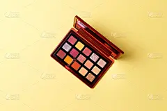 Mua和女孩的概念。眼影调色板以黄色为背景，眼影化妆品作为奢侈品美容品牌的推广产品。时尚博客的设计。