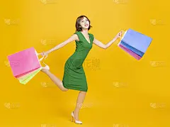 快乐的年轻女人拿着购物袋和跑步