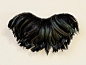 奶油色背景上带有彩虹色黑色羽毛的复古羽毛颈饰的照片