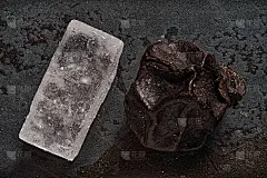 放大2.5倍的微距镜头，在锻造的铁片上拍摄一粒粗盐和一粒黑胡椒