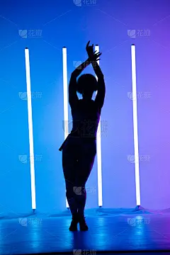 年轻时尚的女孩在霓虹灯的彩色背景下跳舞的工作室。音乐dj海报设计。黑暗的轮廓