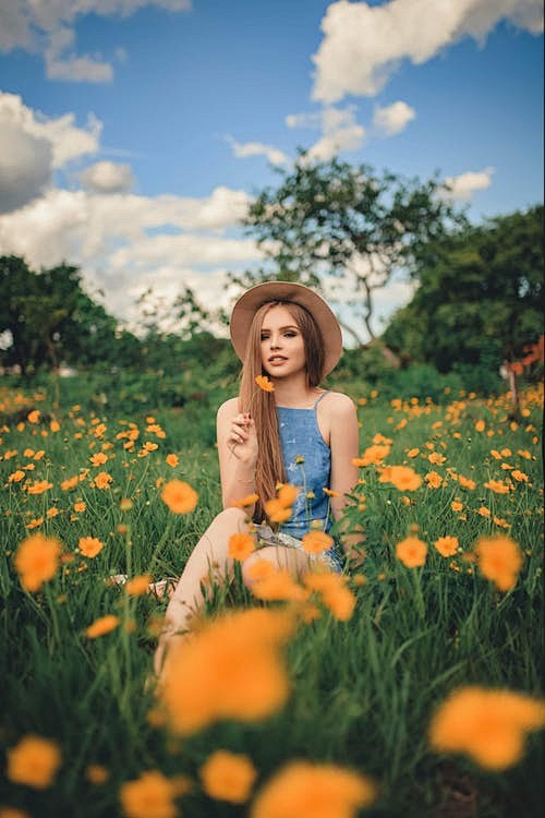 女人坐在黄色的花田