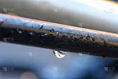 雨滴悬挂在钢条上