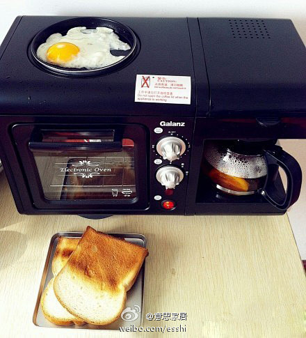 早餐机投入使用。面包已经烤好了，现在在煎...