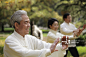 Mature people doing Tai Chi together in a park