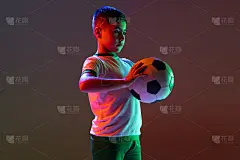 男孩的裁剪肖像，孩子，足球运动员训练孤立的梯度背景在霓虹灯。