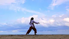 在海滩上练习武术的年轻女性的慢动作。