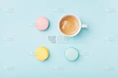 温馨的早餐。咖啡杯和彩色马卡龙在淡蓝色背景俯视图。时尚公寓。甜杏仁饼。