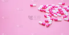 粉白色抗生素胶囊药丸散布在粉红色的背景与空间。药房旗帜。抗生素胶囊药片。药房商店壁纸。制药行业。抗菌