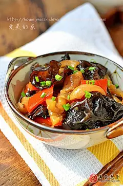 [肉皮小炒] 材料：猪肉皮、黑木耳、红椒、豆豉、生抽、蚝油、料酒、食用油、盐、糖、姜、葱、八角、香叶。做法：1、洗净的猪皮放在锅中，加一大勺料酒煮开。2、煮到肉皮变色后捞出，刮去肉皮上的肥肉去干净毛后，将肉皮切成小块。3、控干水份后放入油锅中用小火炸至金黄色捞出。4、放在冷水中，泡一个晚上。5、高压锅烧热后倒入适量油。6、将切好的葱段，姜片，八角和香叶倒入炒香。7、将泡好的肉皮倒入翻炒。8、调入生抽。9、加入洗干净的豆豉。10、加入蚝油。11、加少许白糖和盐。12、加入淹过肉...... #年夜饭#