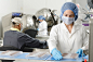 three people inside factory wearing masks and coats