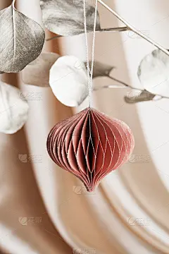 圣诞蜂巢纸装饰在金黄色的树枝上米色的背景与纺织品。节日、贺卡、环保节日。