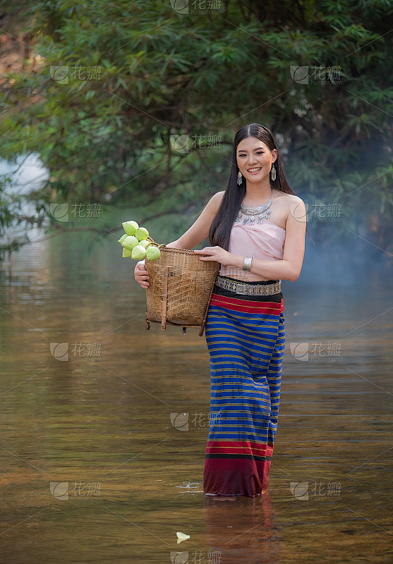 美丽的女人穿着北方风格的衣服站在小溪。