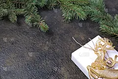 圣诞构图的冷杉枝，金丝带，礼品盒在牛皮纸上黑色与金色浮雕背景与文字的地方。