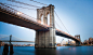 The Brooklyn Bridge with the Brooklyn skyline in the distance in New York City