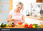 stock-photo-cute-woman-cuts-paprika-for-salad-sitting-at-the-kitchen-table-170303630