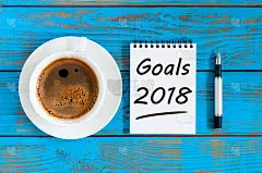 2018年的目标在纸笔记的背景和早上的咖啡杯在蓝色的木头桌子上，目标，目标，梦想和新年的承诺下一年