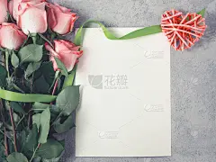 插花——一束粉色玫瑰，一个柳条心和一张空纸片，用于在混凝土表面题字，设计模板或贺卡，俯视图，平躺